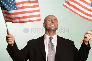 Mann schwenkt amerikanische Flaggen