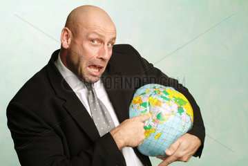 Mann zeigt auf einen aufblasbaren Globus