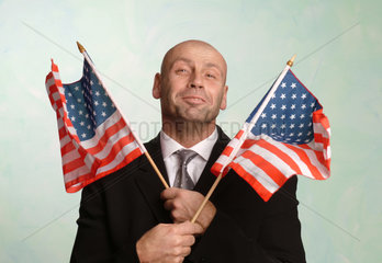 Mann schwenkt amerikanische Flaggen