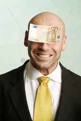 Mann mit Geldschein auf der Stirn