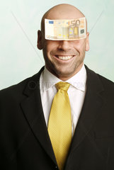 Mann mit Geldschein auf der Stirn