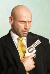 Mann posiert mit Waffe