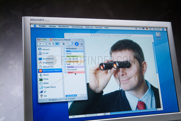 Hamburg  Mann mit Fernglas auf einem Computer