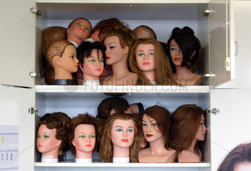 Haarmodellkoepfe im Schrank einer Berufsschule