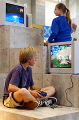 Jugendliche spielen mit der Sony Playstation 2 auf der You Messe