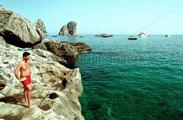 Capri  ein Mann steht an einem felsigen Strand