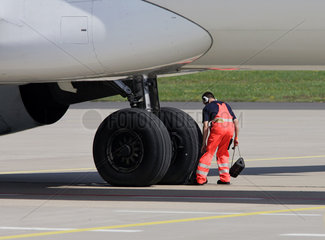 Flughafen  ein Arbeiter sichert ein Flugzeug
