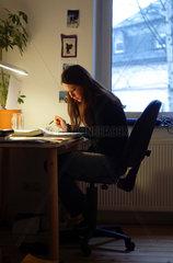 Studentin sitzt am Schreibtisch und lernt