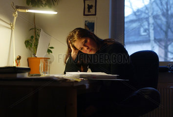 Studentin sitzt am Schreibtisch und lernt