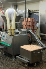 Wurstproduktion  ein Fleischer saeubert den Behaelter der Wurstmaschine