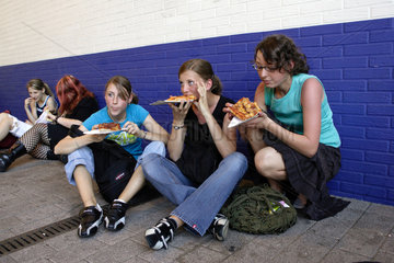 Maedchen essen Pizza auf der Jugendmesse YOU in Essen