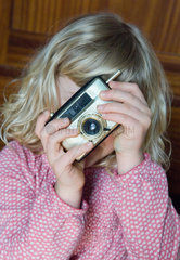 Berlin  Kind spielt mit einer Kamera