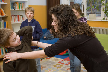 Berlin  Deutschland  Grundschulkind uebt mit Lehrerin Selbstverteidigung