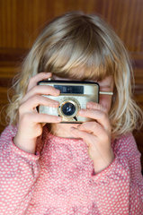 Berlin  Kind spielt mit einer Kamera