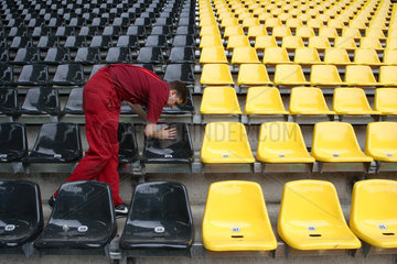 Ein Mann in rot putzt schwarze und gelbe Sitze
