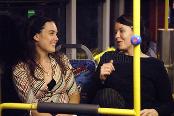 Jugendliche Frauen fahren mit dem Nachtbus durch Koeln