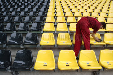 Ein Mann in rot putzt schwarze und gelbe Sitze