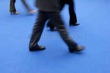 Business  Menschen gehen ueber einen blauen Teppich