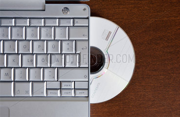 Laptop mit CD-Brenner auf braunem Holzfurnier