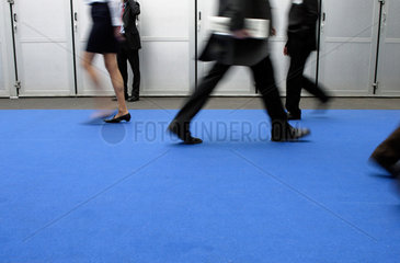 Business  Menschen gehen ueber einen blauen Teppich