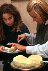 Jugendliche Frauen essen Kaesekuchen