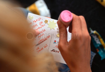 Jugendliche Frau bastelt eine Grusspostkarte