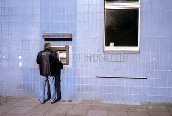 Berlin  ein Mann steht vor einem Geldautomaten in Berlin Charlottenburg
