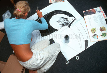 Jugendliche Frau malt einen Tukan