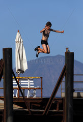 Alicudi  Italien  Junge springt von einem Bootssteg ins Wasser