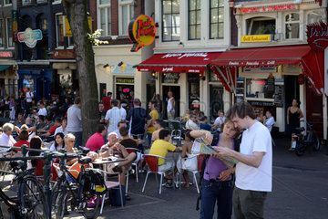 Amsterdam  Strassencafe  Touristen mit Stadtplan