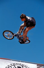 Jugendlicher BMX-Fahrer fliegt durch die Luft