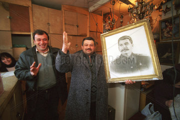 Haendler mit Stalin-Bild auf Troedelmarkt in Tiflis