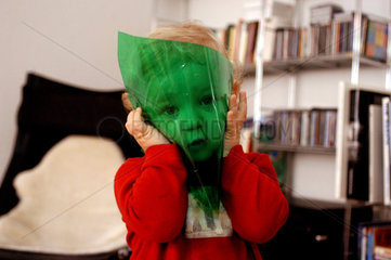 Kind spielt mit gruener Folie