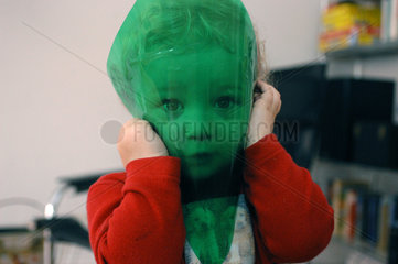 Kind spielt mit gruener Folie