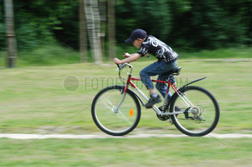 Junge faehrt Rad im Park  Berlin