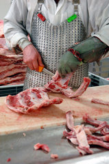 Fleischer zerteilt eine Schweinerippe  Berlin