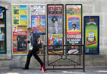 Avignon  Frankreich  ein Mann passiert eine Wand mit Werbeplakaten