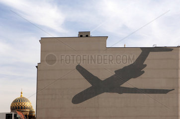 Schatten eines Verkehrsflugzeugs auf einer Hauswand  Berlin