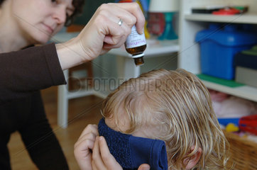 Mutter behandelt ihr Kind gegen Kopflaeuse  Berlin