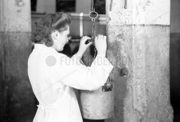 Dresden  DDR  Laborantin wiegt einen Eimer mit Milch