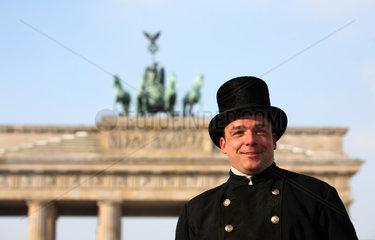 Berlin  Deutschland  ein Schornsteinfeger vor dem Brandenburger Tor