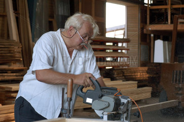 Tischlermeister beim Zuschnitt von Holzbalken