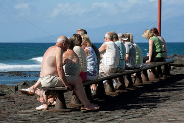 Playa de las Americas  Spanien  Senioren sonnen sich auf einer Bank vor dem Meer auf Teneriffa