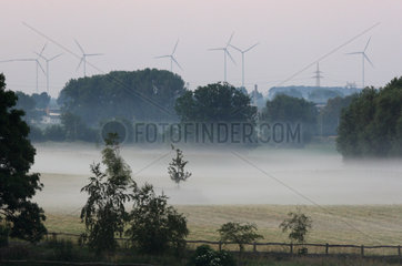 Goerlsdorf  Deutschland  Windraeder hinter einer nebelverhangenen Weide