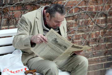 Hoppegarten  Deutschland  Mann liest in einem alten Rennkurier