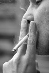 Mann zieht genussvoll an einer Zigarette