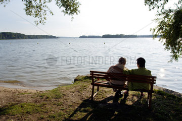 Bad Saarow  ein aelteres Paar sitzt am Scharmuetzelsee