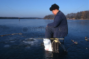 Eisangler fischt auf dem Hoelzernen See bei Berlin