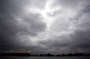 Frachtschiff im Hafen von Bremerhaven vor dramatischem Himmel