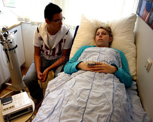Patientin mit Partner nach einer ambulanten Operation im Aufwachraum